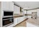 Modern kitchen boasts stainless steel appliances, granite countertops, and white cabinetry at 19026 W Stella Ave, Waddell, AZ 85355