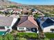 Aerial view of a landscaped backyard with artificial turf, covered patio and outdoor dining. Mountains in the background at 20363 W Coolidge St, Buckeye, AZ 85396