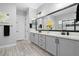 Bathroom featuring double sinks, a large mirror, gray cabinets, and modern fixtures at 20363 W Coolidge St, Buckeye, AZ 85396