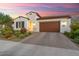 Beautiful single-story home with brown garage door, desert landscaping, and a colorful sunset at 20363 W Coolidge St, Buckeye, AZ 85396