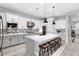 Spacious kitchen features white cabinets, stainless steel appliances, a large island with seating and modern pendant lights at 20363 W Coolidge St, Buckeye, AZ 85396