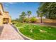 Landscaped backyard with a brick pathway and lush green lawn at 21525 E Camacho Rd, Queen Creek, AZ 85142