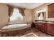 Elegant bathroom with soaking tub and granite vanity at 21525 E Camacho Rd, Queen Creek, AZ 85142