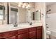 Double sink bathroom vanity with a large mirror and tub at 21525 E Camacho Rd, Queen Creek, AZ 85142