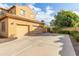 Two-car garage with light tan exterior and driveway at 21525 E Camacho Rd, Queen Creek, AZ 85142