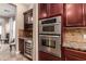 Built-in wine fridge and double ovens in the kitchen at 21525 E Camacho Rd, Queen Creek, AZ 85142