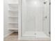 Modern bathroom with glass-enclosed shower showcasing white marble-look tile and built-in shelving at 2324 W Moody Trl, Phoenix, AZ 85041