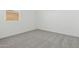 Clean, empty bedroom with carpeted floor and a large window providing natural light at 2324 W Moody Trl, Phoenix, AZ 85041