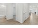 Hallway with wood flooring and white walls connecting to a bathroom and other rooms at 2324 W Moody Trl, Phoenix, AZ 85041