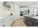 Contemporary kitchen featuring white cabinets, stainless steel appliances, and a stylish backsplash design at 2324 W Moody Trl, Phoenix, AZ 85041