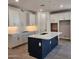 Modern kitchen featuring white cabinets, a dark blue island, and marble countertops at 2324 W Moody Trl, Phoenix, AZ 85041