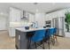 Bright kitchen showcasing a large island with seating, stainless steel appliances, and modern white cabinets at 2324 W Moody Trl, Phoenix, AZ 85041