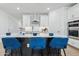Modern kitchen boasts an island with white countertop, stylish blue seating, and stainless steel appliances at 2324 W Moody Trl, Phoenix, AZ 85041