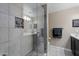 Modern shower with glass enclosure, tile surround, and pebble floor at 240 W Juniper Ave # 1173, Gilbert, AZ 85233