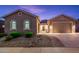 Tan colored house with a two-car garage and nicely landscaped front at 24018 N 165Th Dr, Surprise, AZ 85387