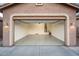 Spacious garage with open overhead door, painted floor, and ample storage space at 24018 N 165Th Dr, Surprise, AZ 85387