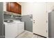 Bright laundry room, washer, dryer, and upper cabinets at 24018 N 165Th Dr, Surprise, AZ 85387