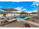 Luxury pool area with lounge chairs and a striped umbrella at 34083 N Paseo Grande Dr, Queen Creek, AZ 85144