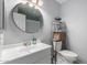 Clean bathroom with a round mirror and a metal shelf at 3511 E Baseline Rd # 1203, Phoenix, AZ 85042