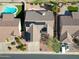 Aerial view of desert home and rooftop solar panels, as well as a neighboring pool at 3727 N Kings Peak N Cir, Mesa, AZ 85215