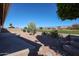 This backyard patio offers access to a golf course view with manicured landscaping and a desert themed garden at 3727 N Kings Peak N Cir, Mesa, AZ 85215