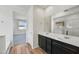 Double vanity bathroom with dark cabinetry and a large mirror at 37550 W San Clemente St, Maricopa, AZ 85138