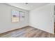 Simple bedroom with large window and wood-look flooring at 37550 W San Clemente St, Maricopa, AZ 85138