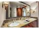 Bathroom with dual vanity, stone countertop, and decorative mirrors at 39863 N 105Th Pl, Scottsdale, AZ 85262