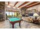 Game room features a pool table, stone fireplace, and ample seating at 39863 N 105Th Pl, Scottsdale, AZ 85262