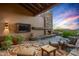 Outdoor patio with fireplace, seating, and stunning sunset views at 39863 N 105Th Pl, Scottsdale, AZ 85262