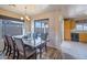 Bright dining room with a glass top table and wood chairs at 43568 W Bedford Dr, Maricopa, AZ 85138