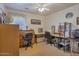 Bright home office features two work stations, ample storage, and a ceiling fan at 43568 W Bedford Dr, Maricopa, AZ 85138