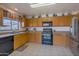 Well-lit kitchen with ample wood cabinetry and appliances at 43568 W Bedford Dr, Maricopa, AZ 85138