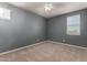 Well-lit bedroom with neutral gray walls and carpet at 5656 N 109Th Ave, Phoenix, AZ 85037