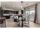 Modern kitchen with dark cabinets, island, and glass dining table at 5656 N 109Th Ave, Phoenix, AZ 85037