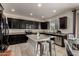 Modern kitchen with dark cabinetry, granite counters, and stainless steel appliances at 5656 N 109Th Ave, Phoenix, AZ 85037