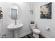 Modern powder room with pedestal sink, toilet, and stylish wall art at 605 N Star Ct, Apache Junction, AZ 85119