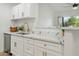 Modern white kitchen with gold hardware, quartz countertops, and stainless steel appliances at 623 W Guadalupe Rd # 223, Mesa, AZ 85210