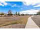 Open green space with a walking path and desert landscaping at 7244 S Sunrise Way, Buckeye, AZ 85326