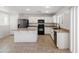 Modern kitchen with white cabinets, black appliances and an island at 7504 S Sundown Ct, Buckeye, AZ 85326