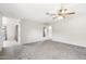 Open living room with grey carpet and multiple doors at 8131 N 107Th Ave # 76, Peoria, AZ 85345