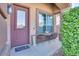 Small front porch with seating for two and lush greenery at 9022 W Ross Ave, Peoria, AZ 85382