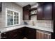 Modern kitchen with dark wood cabinets, stainless steel appliances, and tile backsplash at 903 W Mackenzie Dr, Phoenix, AZ 85013