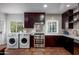 Modern kitchen with dark wood cabinets, stainless steel appliances, and tile backsplash at 903 W Mackenzie Dr, Phoenix, AZ 85013