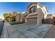 Two-story house with a gray garage door, artificial turf, and a black fence at 9823 E Escondido Ave, Mesa, AZ 85208