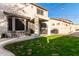 Two-story house with backyard patio, string lights, and grass at 9823 E Escondido Ave, Mesa, AZ 85208