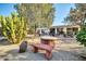 Landscaped backyard with cactus plants, a stone bench and a patio at 10202 N 100Th Dr, Sun City, AZ 85351