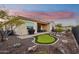 Landscaped backyard with putting green and hot tub at 2317 N Beverly Pl, Buckeye, AZ 85396