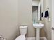 Clean powder room with pedestal sink and toilet at 2317 N Beverly Pl, Buckeye, AZ 85396