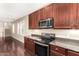 Kitchen features dark wood cabinets, granite countertops, and stainless steel appliances at 4095 E Jasper Dr, Gilbert, AZ 85296